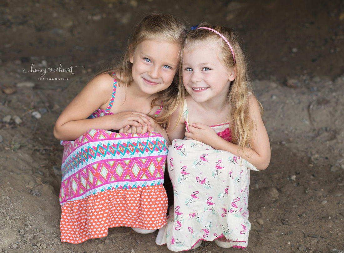 Sisters huddled together child photography outdoor session in Calgary Alberta