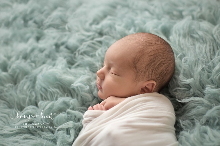 Side profile of sleeping baby boy laying on Luneberry's Dutch Blue Flokati - Calgary Newborn Photographer