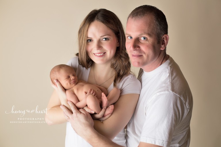 Mom dad and baby photo first family photo studio pose