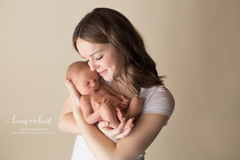Mom holding newborn son Calgary Newborn Photography session